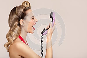 Joyful pin-up girl shout on retro phone
