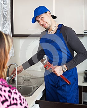 Joyful plumber repairing running water