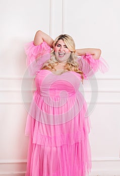 Joyful plus size model in pink dress