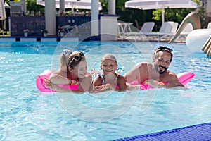 Joyful positive family having fun in the pool