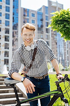 Joyful positive man using his bicycle
