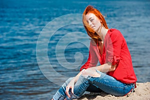 Joyful redhead woman sitting comfortably and smiling