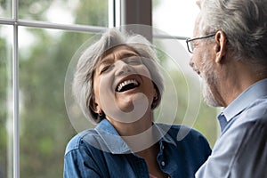 Joyful retired husband make beloved aged wife cry with laughter