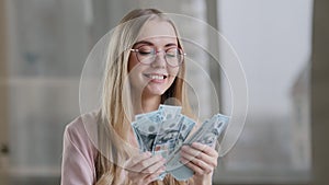 Joyful rich girl counting cash in office successful caucasian lady businesswoman getting bundle of money happy woman