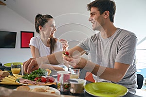 Joyful romantic cople having breakfast together