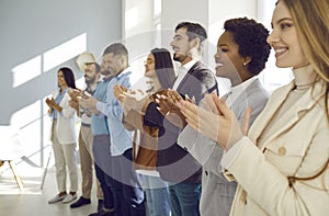 Joyful and satisfied audiences applaud speaker during business conference or seminar.