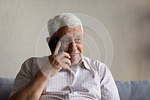 Joyful sincere old man holding cellphone call conversation.