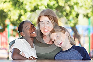 Joyful single parent with sons at park table