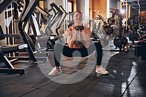 Smiling fit female during strength workout in gym photo