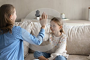 Joyful small kid girl giving high five to mother.