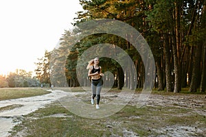 Joyful sportive girl running outdoors