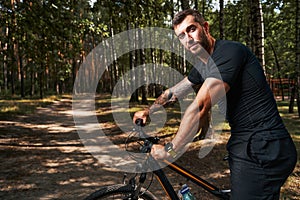 Joyful sporty man enjoying day in forest