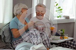 Joyful spouses sharing a laugh and enjoying breakfast