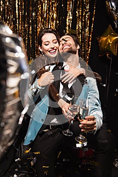 joyful and stylish couple clinking champagne