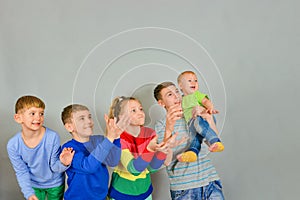 Joyful and surprised children catch a falling object from above. The rivalry between the children who first catch