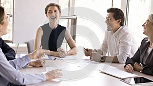 Joyful team members having conversation during seminar or morning briefing