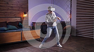 Joyful teen in VR goggles performing funny dance