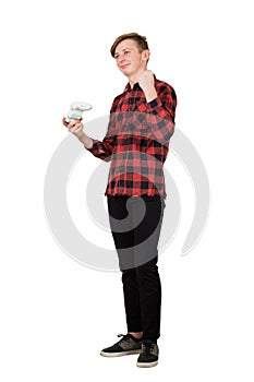 Joyful teenage boy playing video games isolated over white background celebrating success raising fist up while holding the