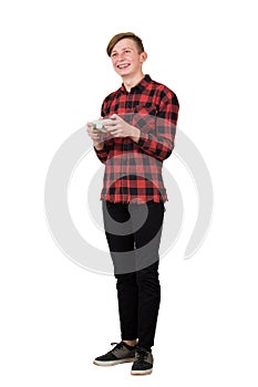 Joyful teenage boy playing video games isolated over white background. Excited guy stand all ears holding a joystick console