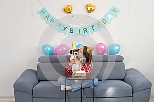 Joyful teenage girl celebrating her dog\'s birthday with tasty cake