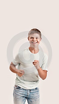 Joyful teenaged disabled boy with Down syndrome smiling at camera while moving forward isolated over white background