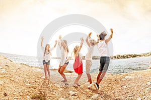 Joyful teens dancing and jumping at the seaside