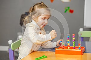 Joyful Toddler Girl Playing with Learning Bead Toy
