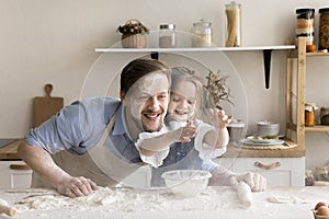 Joyful toddler kid and daddy enjoying funny baking activity