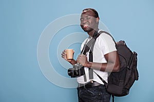 Joyful tourist having DSLR device while being excited for citybreak photo