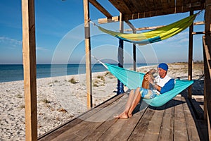 Joyful traveler with funny dog relaxing in a hammock