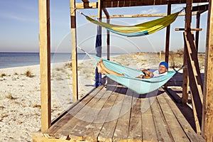 Joyful traveler with funny dog relaxing in a hammock