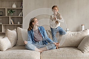 Joyful two generations family doing yoga exercises at home.