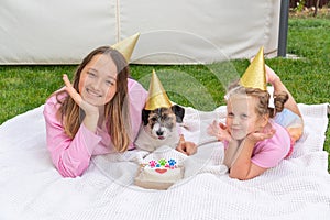 Joyful two girls sisters celebrating their dog\'s birthday