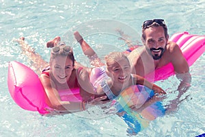 Joyful united family swimming together on the air bed