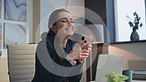 Joyful winner rejoicing cellphone at modern office closeup. Woman feeling happy