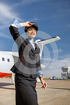 Joyful woman airline worker standing outdoors at airfield