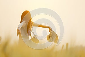 Joyful woman in barley field in summer sunset