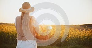 Joyful Woman with Basket in Oilseed Rape Field