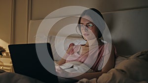 Joyful woman browsing laptop at home night closeup. Smiling girl typing message