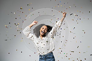 Joyful woman celebrating with falling confetti. Birthday, Christmas or New Year eve celebration, having fun, enjoy life concept