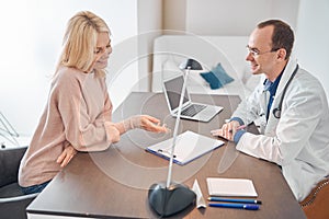 Joyful woman consulting with a general practitioner