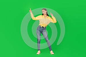 Joyful Woman Dancing Listening To Music Over Green Background