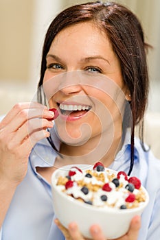 Joyful woman eating cereal in the morning