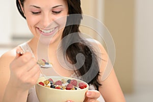 Joyful woman eating healthy cereal
