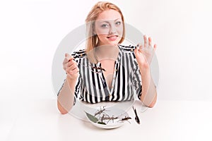 Joyful woman eating insects with a fork in a restaurant