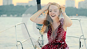 Joyful Woman Enjoying Yacht Ride, Young woman in a red dress laughing aboard a yacht, with the breeze in her hair.