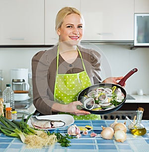 Joyful woman with frying pan