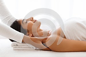 Joyful woman getting relaxing body shoulders massage at wellness center