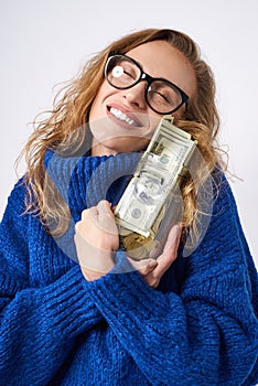 Joyful woman holding piggy bank and money
