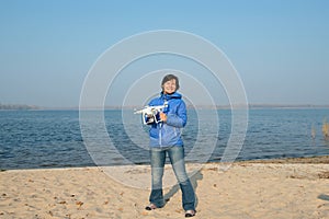 Joyful woman holding a quadcopter, drone and enjoying life on th